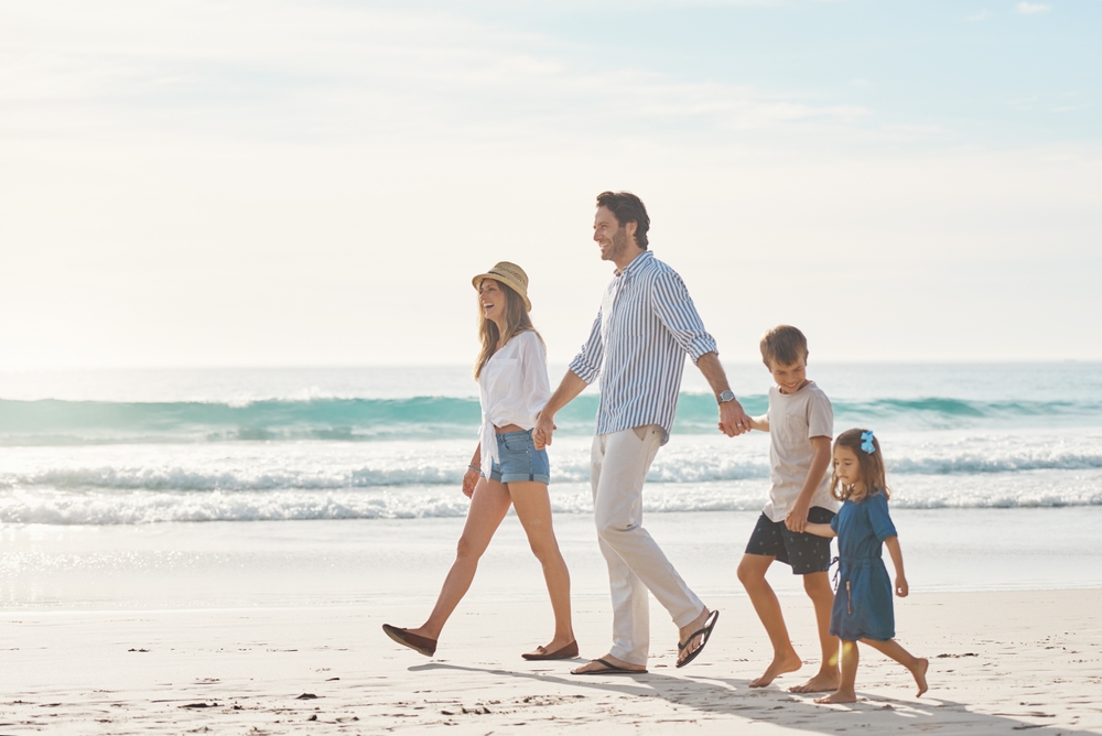 Charleston Spring Break: A young mom and dad walk along the shoreline with their son and daughter.